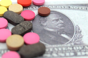There are a lot of multi-colored medical pills on a dollar bill.