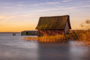 Bootshütten am Plauer See in der Meckelnburgischen Seenplatte zu Sonnenaufgang - obrazy, fototapety, plakaty