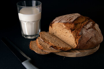 photo of sliced bread with a glass of milk and a knife next to it