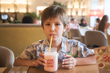 A child drinking a milkshake in a cafe
