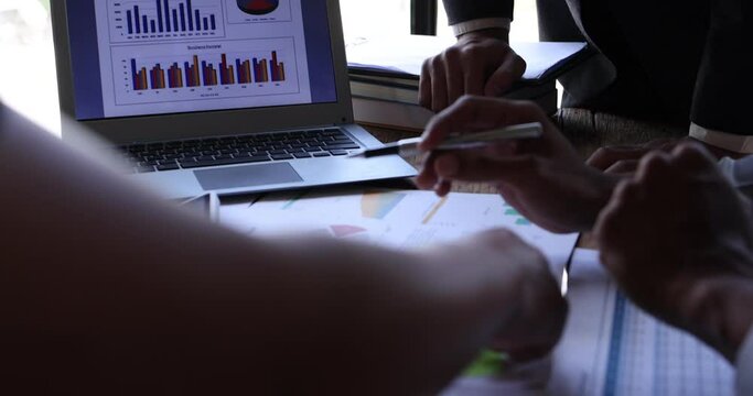 Business People Meeting using laptop computer,calculator,notebook,stock market chart paper for analysis Plans to improve quality next month. Conference Discussion Corporate Concept