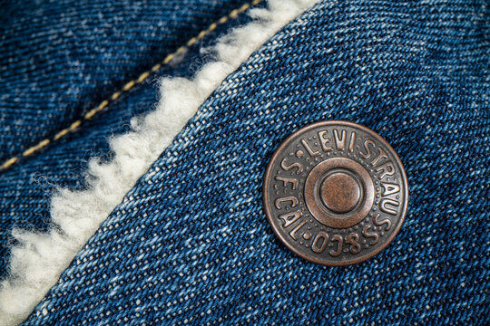 Fort Collins, CO, USA - November 14, 2022: Closeup of a metal button on Levi-Strauss trucker jacket. Levi Strauss Co. is American clothing company known worldwide for its Levis brand of denim jeans.