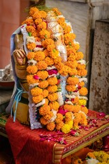 Vertical shot of the Shiva god with Hindu religoius flowers offering