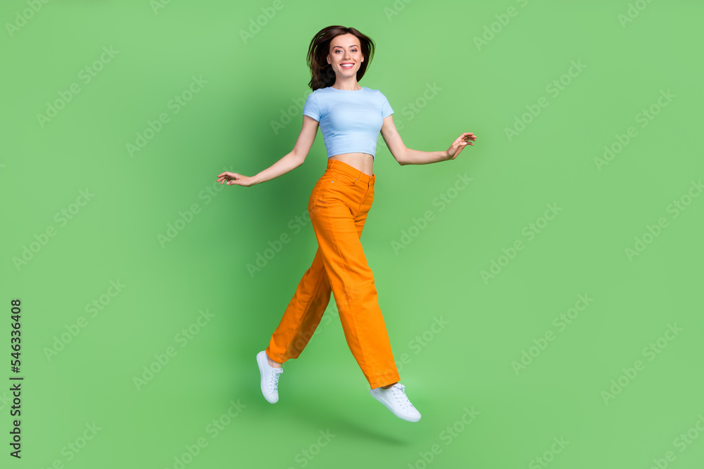 Sticker Full body profile portrait of carefree pretty lady jump hurry rush isolated on green color background