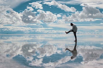 Young man walking through the Salar de Uyuni in Bolivia.