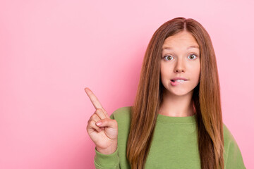 Photo of curious nice girl with straight hairstyle wear green sweater directing empty space biting lip isolated on pink color background © deagreez