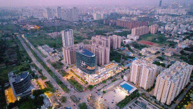 flying away aerial drone shot showing brightly lit modern buildings in gurgaon delhi india showing the lights and cityscape in the distance