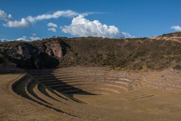 Terraces inside the Moray Ruins during sunset overlooking the mountains, Sacred Valley, Peru.