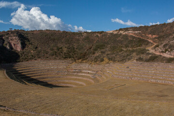 Terraces inside the Moray Ruins during sunset overlooking the mountains, Sacred Valley, Peru.