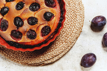 Fresh homemade plum pie in ceramic form on grey concrete background. Plum Skillet Cake. Delicious summer dessert. Selective focus - 546343062