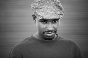 Black and white portrait of cool young black guy with cap