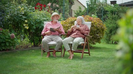 Senior couple sitting in garden, relaxing, having a conversation. - Powered by Adobe
