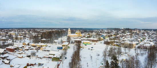 Panorama of a small city in the depths of Russia from a height. Orthodox churches and traditional old wooden houses, Kologriv in the Kostroma region and a winter view of the city