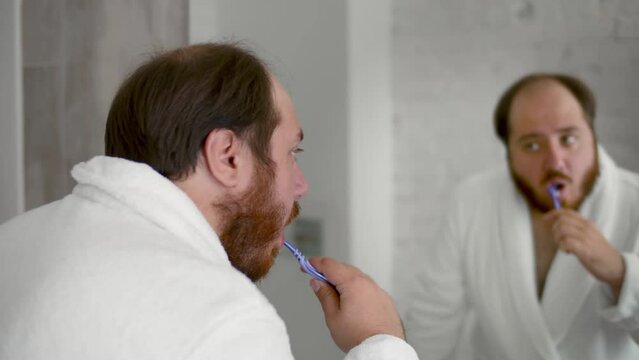 Man brushing teeth for dental healthcare, cleaning mouth with toothbrush in bathroom. Realtime