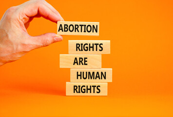 Abortion rights symbol. Concept words Abortion rights are human rights on wooden blocks Businessman...