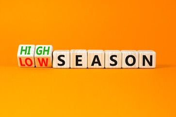 High or low season symbol. Concept words High season and Low season on wooden cubes. Beautiful orange table orange background. Business high or low season concept. Copy space.