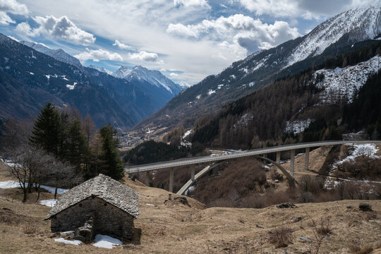View from Pian San Giacomo on the descent from the San Bernardino pass to Mesocco in the Grisons, Switzerland, showing an old stone barn and a modern concrete bridge.