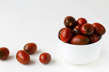 Fresh red cherry tomatoes with water drops on white background. cherry tomatoes in the white bowl. copy space.