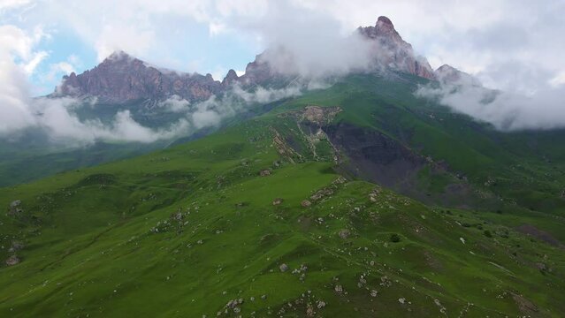 Aerial view of the mountainside and beautiful alpine green meadows