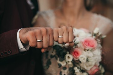 Obraz na płótnie Canvas Closeup shot of the bride and groom wearing their new wedding rings