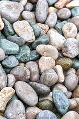Multicolored pebbles on the sea beach as a background extreme close view