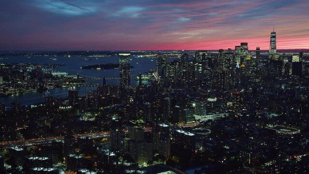 Aerial view of Famous Skyscrapers in Lower and Midtown Manhattan at Sunset. Manhattan Bridge in the background. New York City, United States. High Quality Footage Shot from Helicopter.
