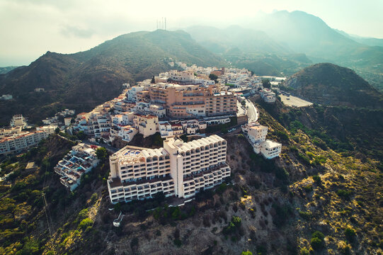 Aerial shot houses rooftops and mountains of Mojacar village. Spain