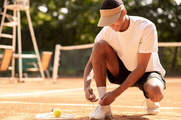 Man in sun visor at the tennis courts before workout