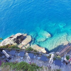 Aerial of underwater stones near the beach with a cafe on the balcony