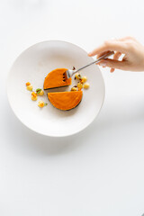 Top view of female tasting yellow Cheesecake. 