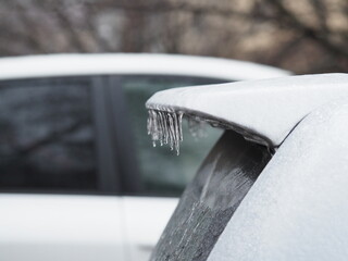 Icy spoiler of a white car close-up