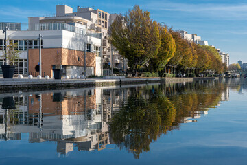 Paris, France - 11 12 2022: Ourcq Canal. Reflections on the Ourcq canal of big trees and buildings