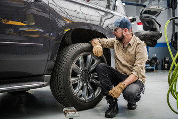 Obraz na płótnie Canvas Mechanic Checking Tire Condition