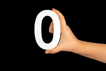 Zero in hand. The number zero is clasped in a hand isolated on a black background. Number zero...