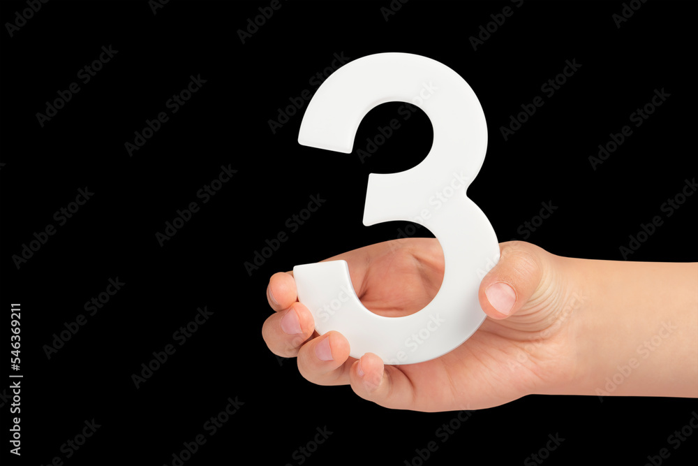 Poster number three in hand isolated on black background. number three in a child's hand on a black backgro