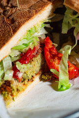 Vegan ingredients stacked up for a falafel sandwich