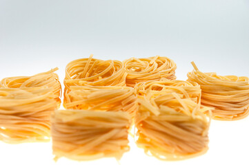 Pasta in the form of nests on a white background close-up.