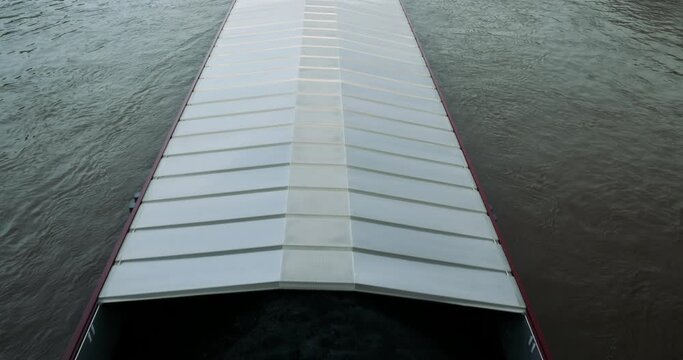 Slow-motion view from above of large taker with covered merchandise - transportation on large river