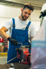 Fototapeta premium Portrait Shot of a Handsome Mechanic Working on a truck workshop Service. Professional Repairman. Modern Clean Workshop.