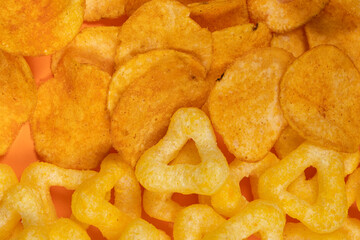 Crispy potato and corn chips, close-up view from above.
