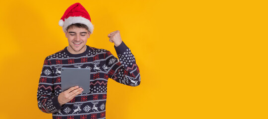 excited young man celebrating with tablet or laptop isolated on background