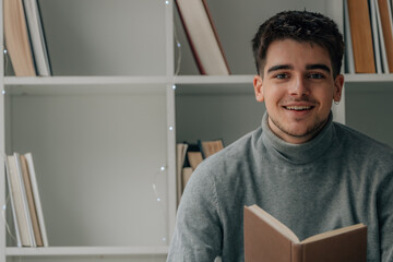 young man at home reading a textbook