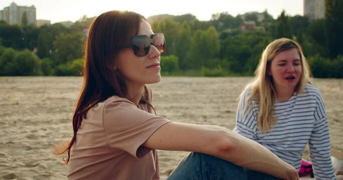 Woman friends having picnic at beach. Medium shot