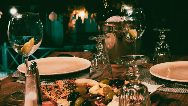 Delicious appetizers prepared for wine on a table, wine bottle,  wine bucket, plates and wine glasses. A pleasant night snack. Delight Plate.