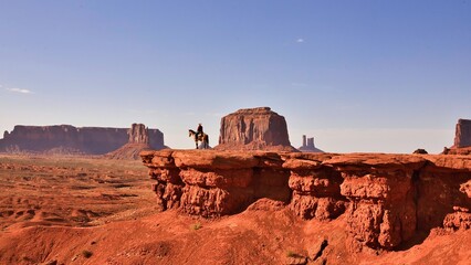 cowboy on horse overlooking Utah bluffs.