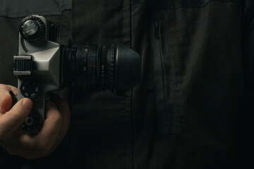 man holding Retro film photo camera isolated on black background soviet
