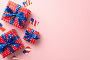 Fototapeta na wymiar USA Independence Day concept. Top view vertical photo of present boxes with bows and national flags on isolated pastel pink background with empty space