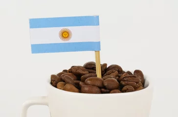Photo sur Plexiglas Bar a café The flag of Argentina sticks out of a cup of roasted coffee beans.