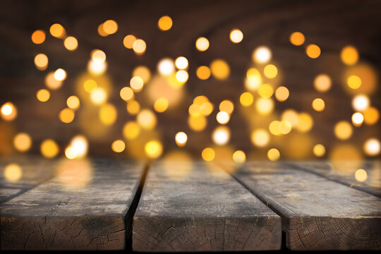 Wooden rustic table, wooden background in the back, a lot of defocused lights