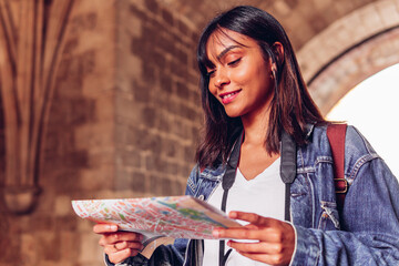 Young woman looking at a map, on adventure travel vacation. Latin tourist girl.